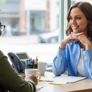 Chaplain and woman talking at work at a desk.